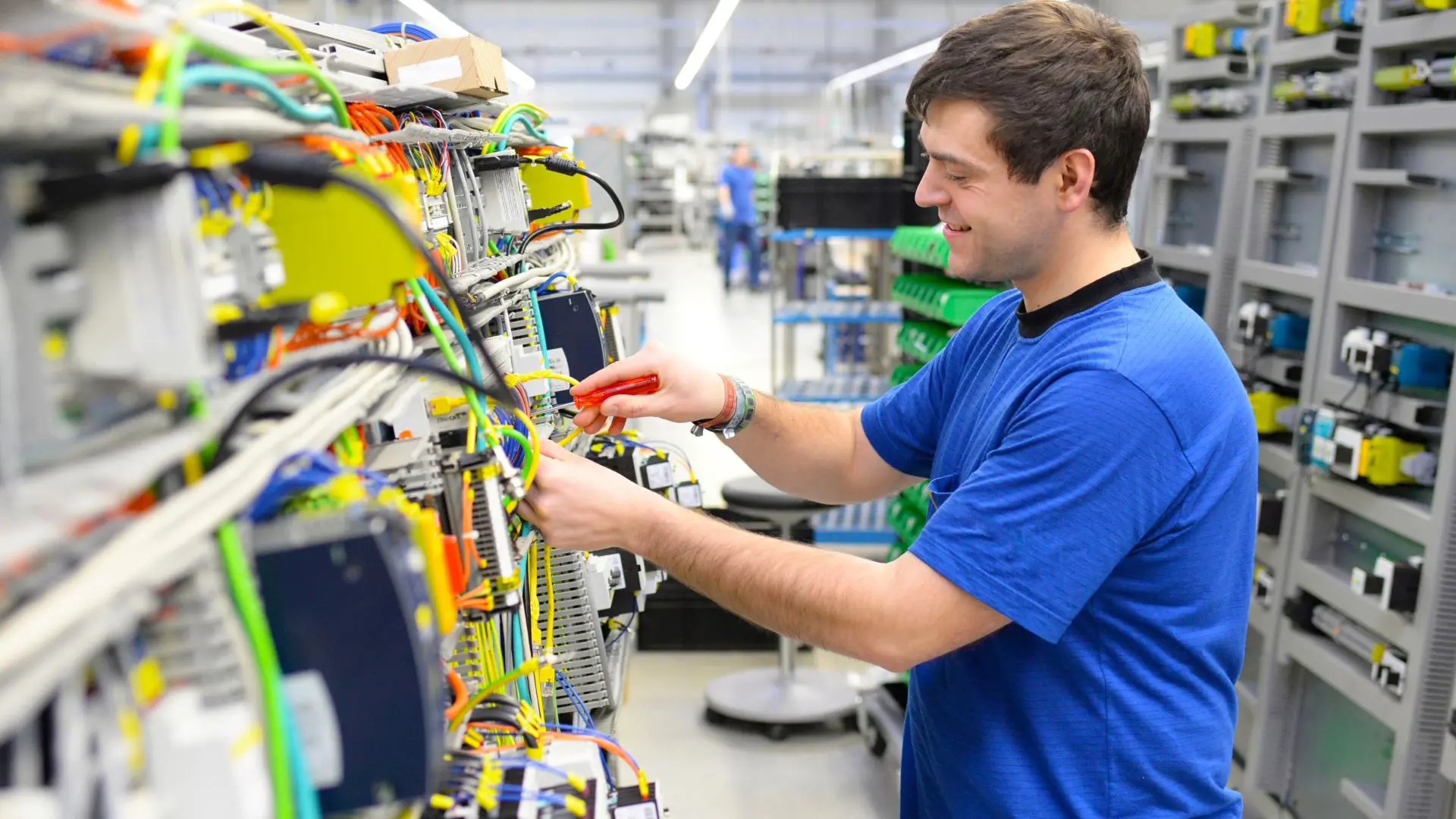 Beispielsweise die Ausbildung zur IndustrielektrikerIn dauert nur 2 Jahre - im Bild: Junger Mann montiert elektronische Bauteile in einer Fabrik.