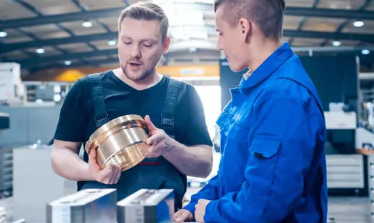 In der Ausbildung gilt nicht der Mindestlohn, sondern die Ausbildungsvergütung. Im Bild: Gewerblich-technischer Azubi im Gespräch mit dem Ausbilder.