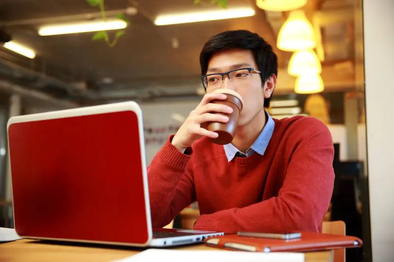 Entspannter Software-Entwickler mit einer Tasse Kaffee bei der Arbeit