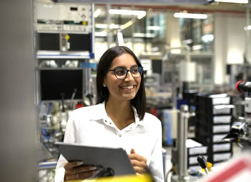 Junge Industriekauffrau bei der Arbeit in der Werkhalle