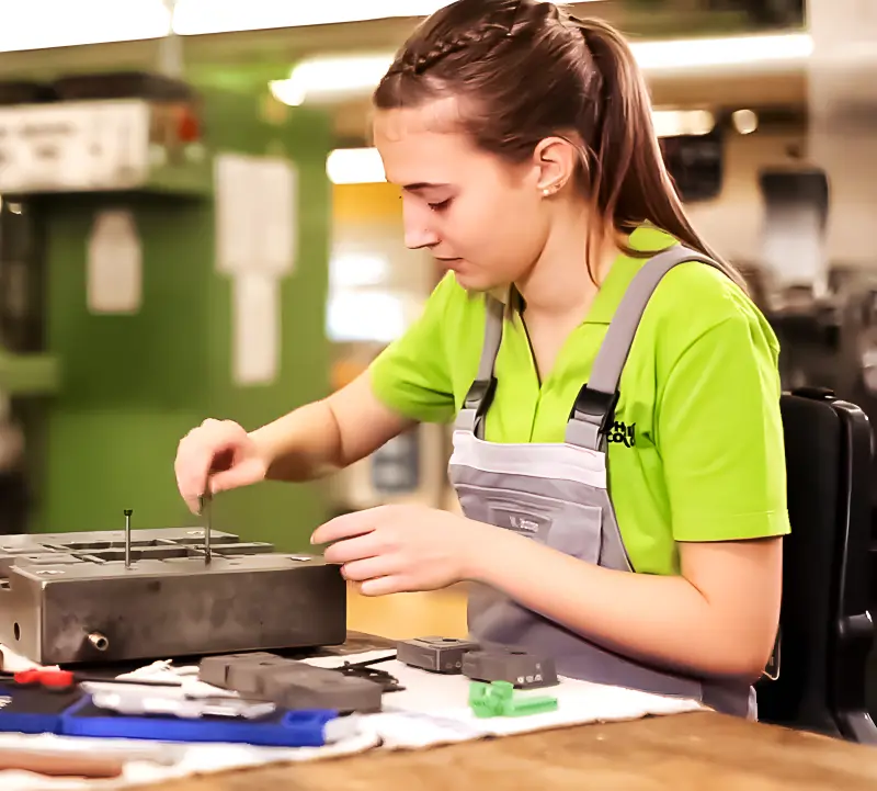 Angehende Werkzeugmechanikerin bei technischen Arbeiten